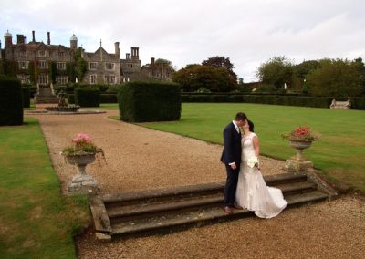 Aimee and Mike kiss on the steps of Eastwell Manor